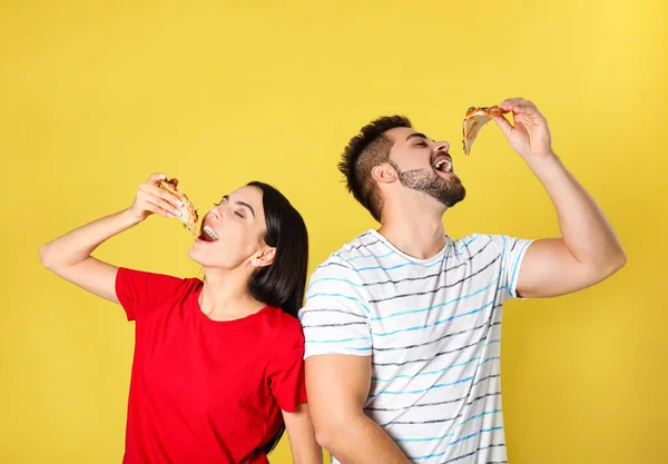 Casal Jovem Comendo Pizza Fundo Amarelo — Fotografia de Stock
