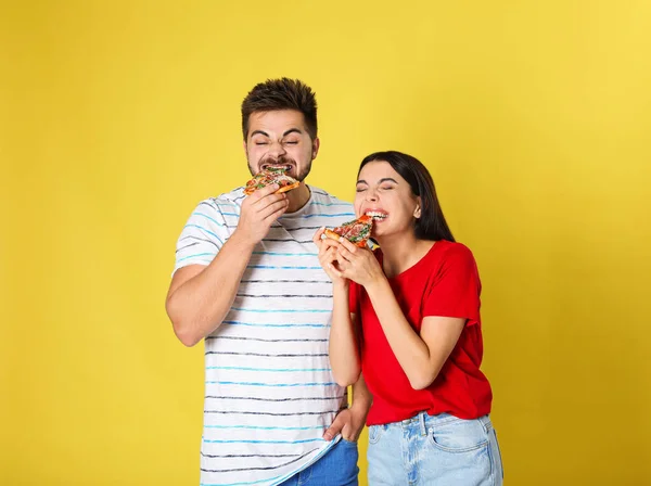 Casal Emocional Comendo Pizza Fundo Amarelo — Fotografia de Stock