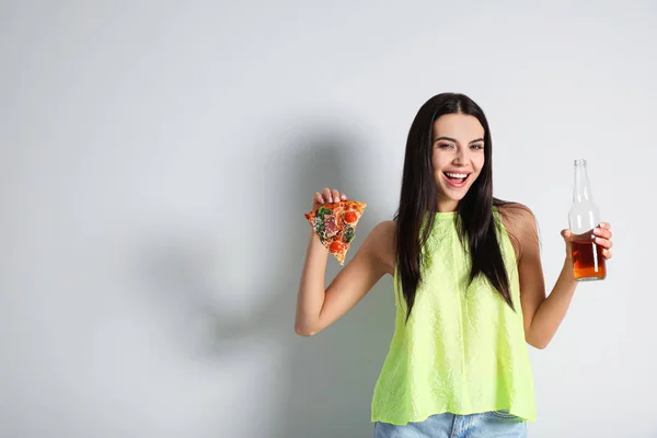 Happy woman with pizza and beer on white background, space for text