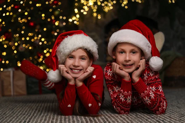 Glückliche Kinder Mit Weihnachtsmützen Auf Dem Fußboden Hause — Stockfoto