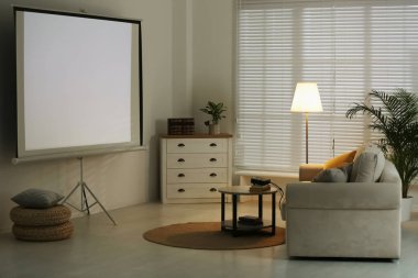 Modern video projektörü ve rahat kanepesi olan şık bir oda.