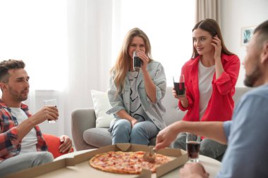 Evde içkili ve pizzalı bir grup arkadaş.