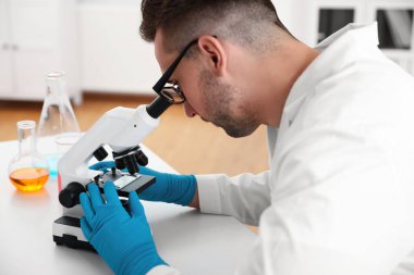 Masada modern mikroskop kullanan bir bilim adamı, yakın plan. Tıbbi araştırma