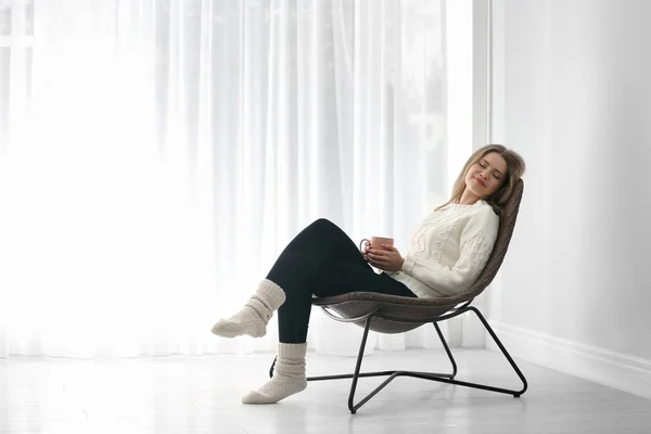 Молода жінка відпочиває в кріслі вдома. Простір для тексту — стокове фото