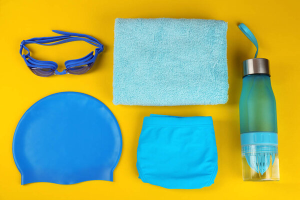 Плоская композиция с плавательными принадлежностями на желтом фоне
