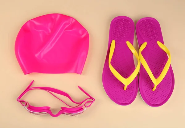 Flat lay composition with swimming accessories on light background