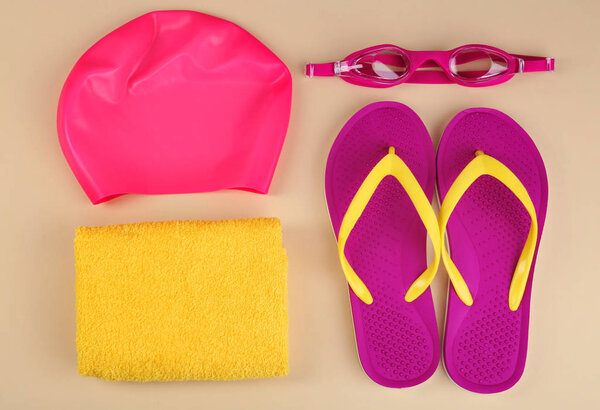 Плоская композиция с плавательными аксессуарами на светлом фоне

