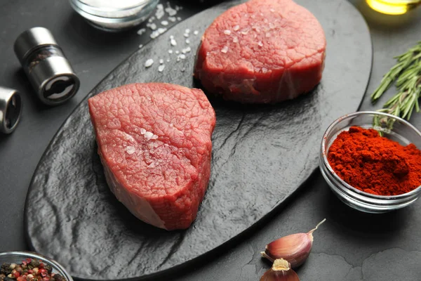 Fresh raw beef cut on black table, closeup