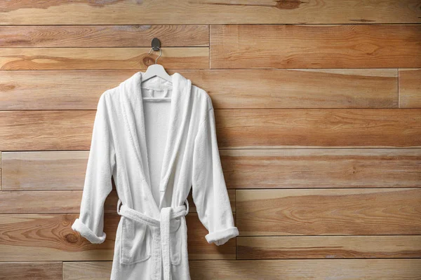软软舒适的浴衣挂在木制墙壁上 文字空间 — 图库照片