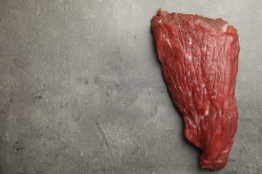 Gri masada taze çiğ biftek, üst manzara. Metin için boşluk