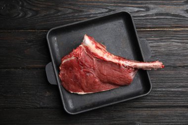 Taze çiğ et, ahşap masadaki kabın içinde kesilmiş.