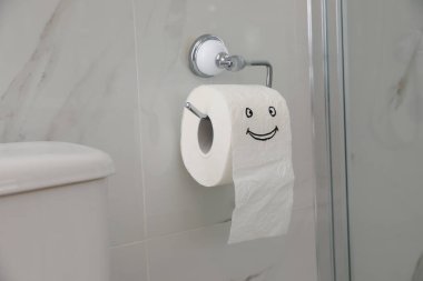 Tuvalet tankının yanında komik suratlı kağıt.