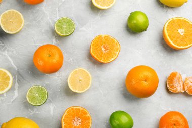 Mandalinalı düz kompozisyon ve gri mermer arka planda farklı turunçgil meyveleri.