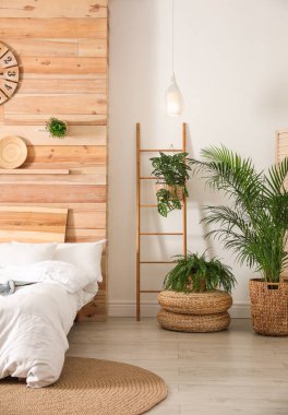 Yeşil bitkilerle süslü şık bir yatak odası. Ev tasarımı fikirleri