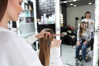 Kuaför, kuaförde profesyonel makasıyla şık saç kesimi yapıyor.