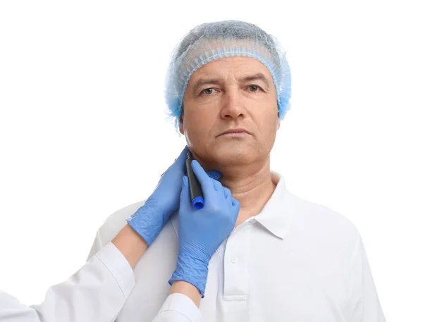 Surgeon with marker preparing man for operation against white ba — Stock Photo, Image