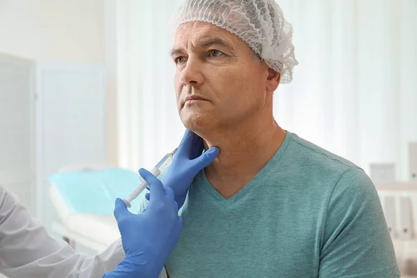 쌍 턱을 병원에서 주사를 맞고 있는 장성 한 남자 — 스톡 사진
