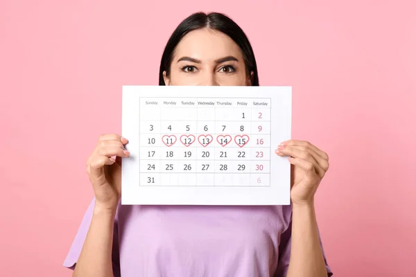 Junge Frau Mit Kalender Mit Markierten Menstruationszyklustagen Auf Rosa Hintergrund — Stockfoto