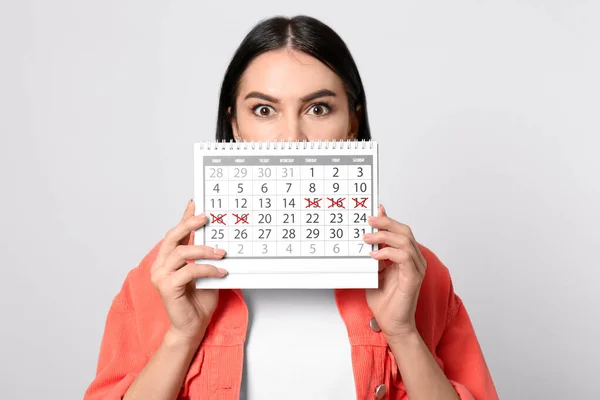 Ung Kvinna Som Håller Kalender Med Markerade Menstruationscykel Dagar Ljus — Stockfoto
