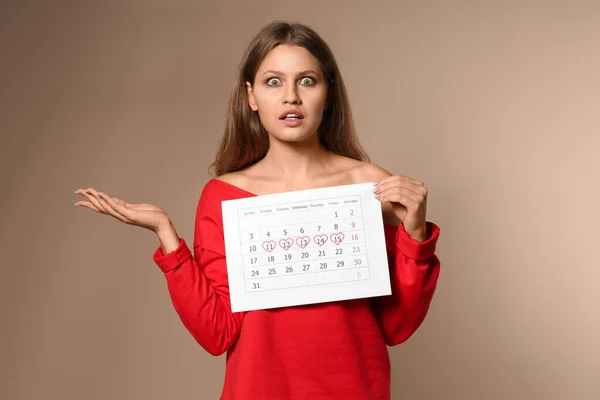 Эмоциональная Молодая Женщина Проводит Календарь Отмеченными Днями Менструального Цикла Бежевом — стоковое фото