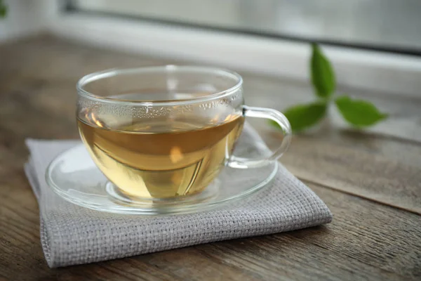 Leckerer heißer grüner Tee in Tasse auf Holztisch, Nahaufnahme — Stockfoto