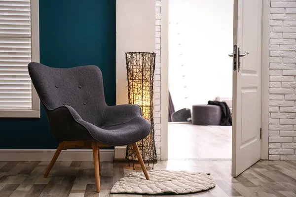 Удобное кресло с напольной лампой и ковром в помещении — стоковое фото