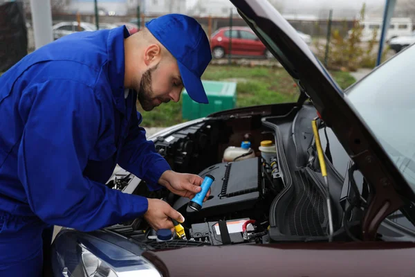 Jovem Mecânico Com Lanterna Fixando Carro Livre — Fotografia de Stock