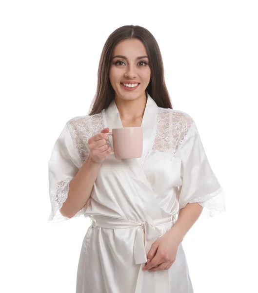 Jovem mulher em roupão de seda com xícara de bebida no backgroun branco — Fotografia de Stock