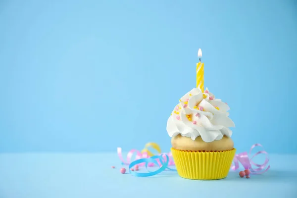 Delicioso cupcake de aniversário com vela no fundo azul claro . — Fotografia de Stock