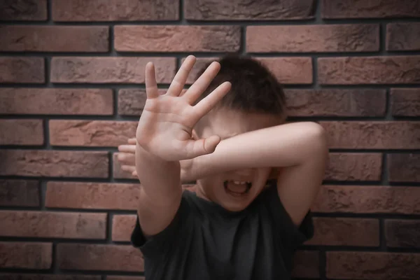 Menino Assustado Fechando Olhos Com Mão Perto Parede Tijolo Criança — Fotografia de Stock