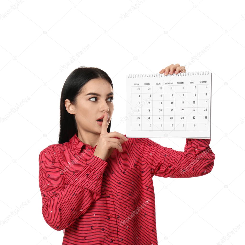 Young woman holding calendar with marked menstrual cycle days on white background