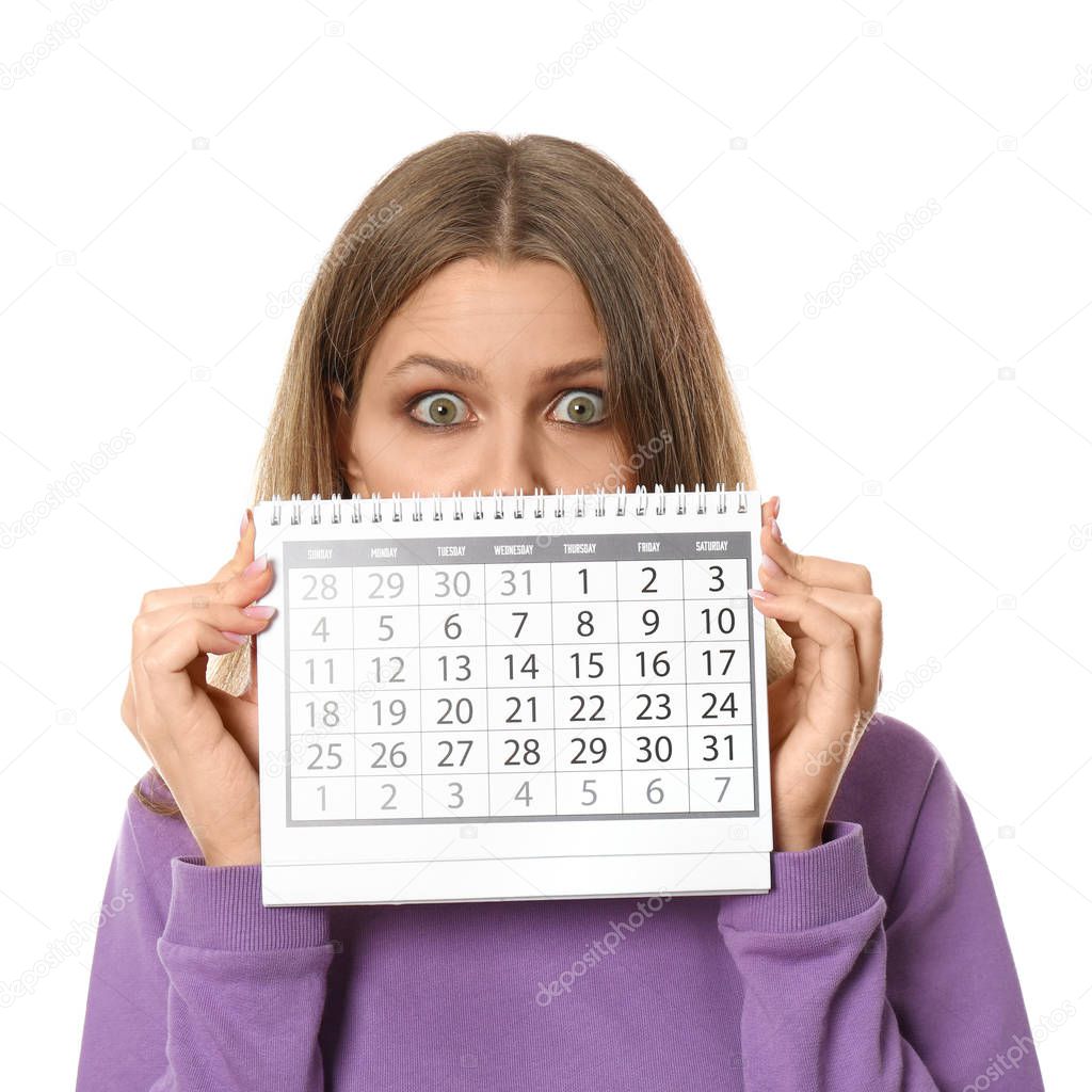 Young woman holding calendar with marked menstrual cycle days on white background