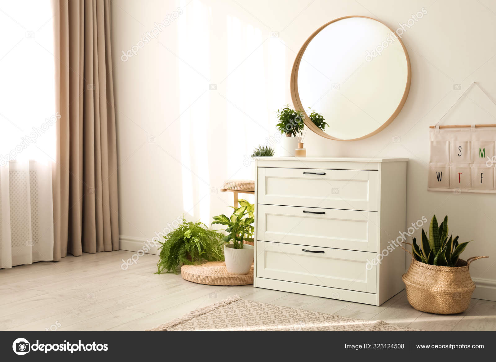 Round mirror over chest outlet of drawers