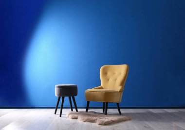 Şık, rahat koltuk ve taburesi olan şık bir oda.