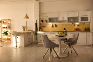 Modern mutfak içi şık beyaz mobilyalarla dolu.