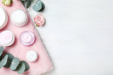 Düz kompozisyon, beyaz ahşap masanın üzerinde krema kavanozları vardı. Evet.