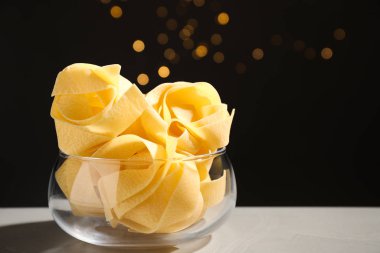Bulanık ışıklara karşı gri masada pişmemiş pappardelle makarna