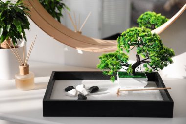 Beyaz masadaki güzel minyatür zen bahçesi.