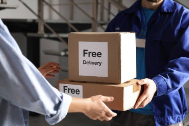 İçerideki kuryeden paket alan kadın, yakın plan.