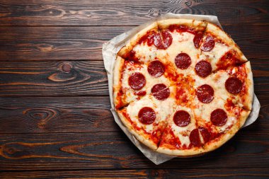 Ahşap masada nefis bir pizza, üst manzara. Metin için boşluk