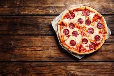 Ahşap masada nefis bir pizza, üst manzara. Metin için boşluk