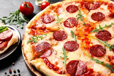 Sıcak, lezzetli pepperonili pizza karanlık masada, yakın plan.