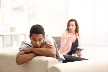 Ofiste Afro-Amerikalı bir çocukla çalışan psikoterapist.