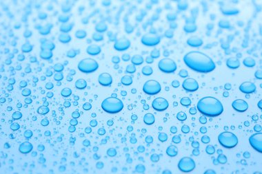 Açık mavi arkaplanda su damlaları, yakın plan görünümü