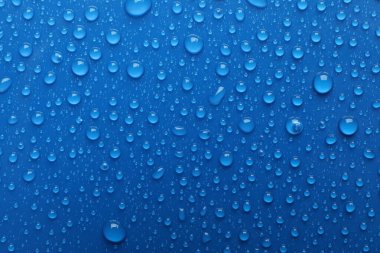 Su damlaları mavi arkaplanda, üst görünümde