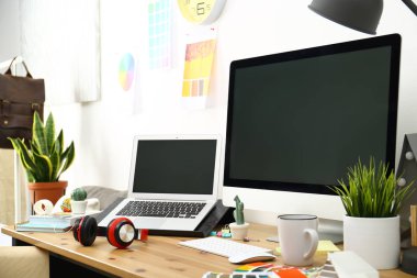 Modern laptop, bilgisayar ve ofis malzemeleri ahşap masada, mesaj için yer var. Tasarımcının işyeri