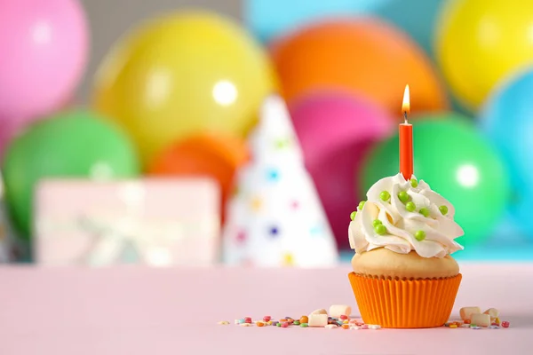 Bolo de aniversário com vela na mesa rosa contra backg borrado — Fotografia de Stock