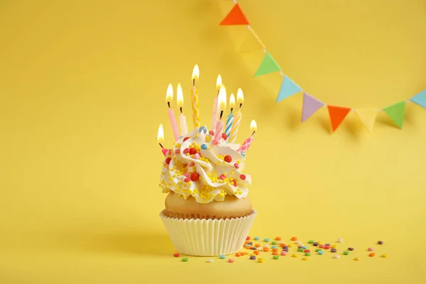 Magdalena de cumpleaños con velas sobre fondo amarillo —  Fotos de Stock