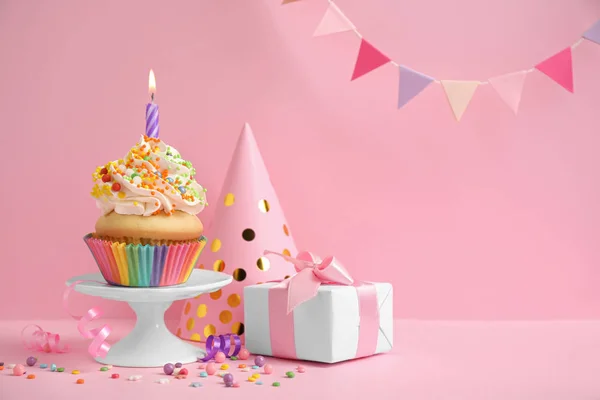 Composição com cupcake de aniversário no fundo rosa — Fotografia de Stock