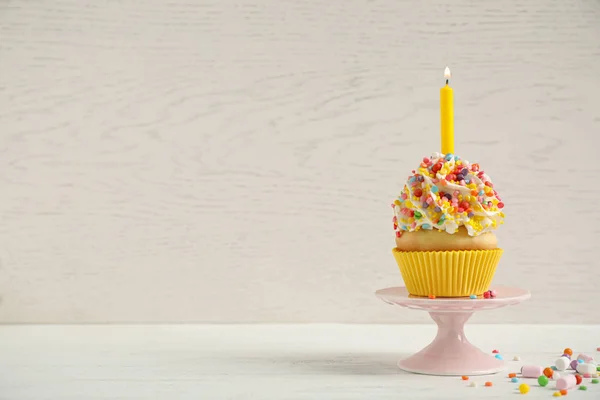 나무등에 대고 하얀 탁자 위에 촛불을 올려 놓은 생일 컵 케익 — 스톡 사진